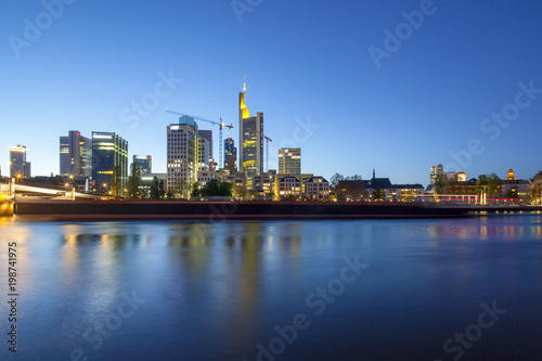 Bankenviertel von Frankfurt in der Abenddämmerung mit vorbeifahrendem Schiff