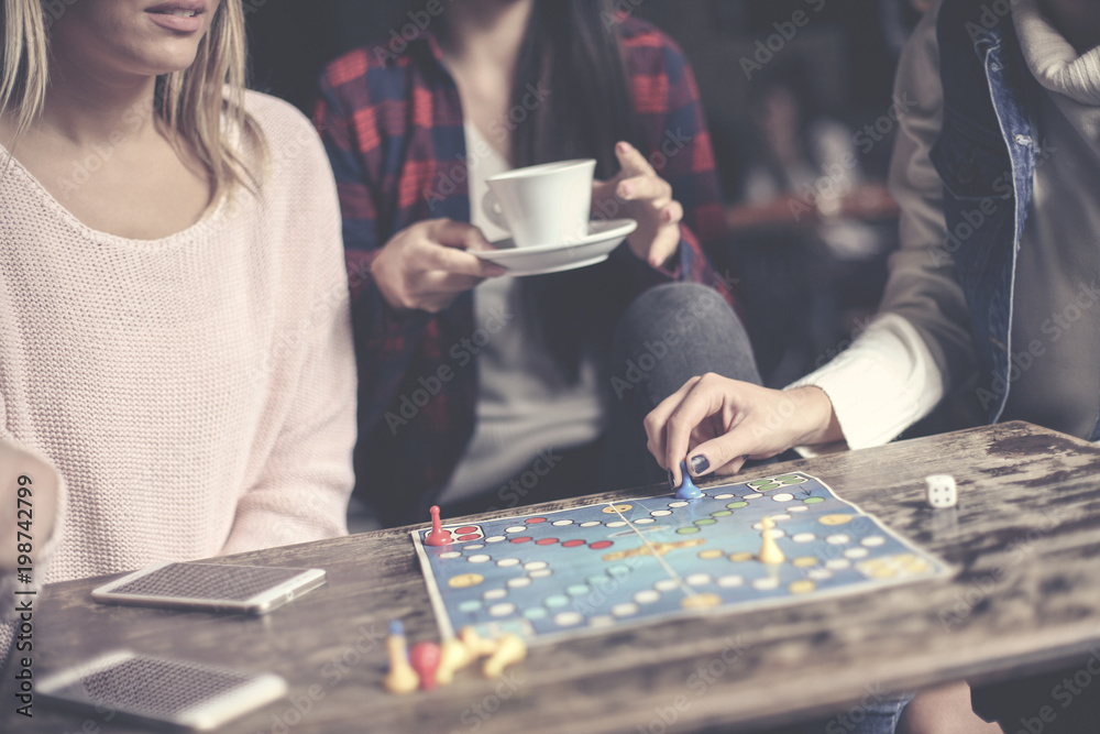 Fototapeta premium Young three girls play together a social game. Focus on hand.