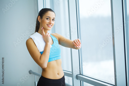 Portrait of young woman in sportswear, doing fitness exercise.