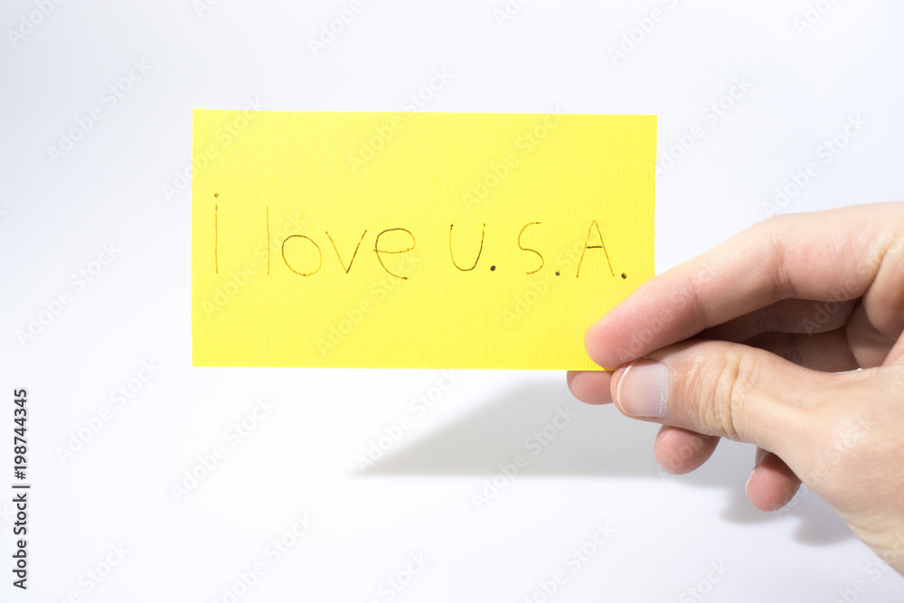 I love U.S.A. handwrite with a hand on a yellow paper