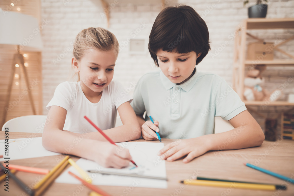 Children at home. Brother and sister are drawing with color pencils. Children at home. Brother and sister are drawing with color pencils.