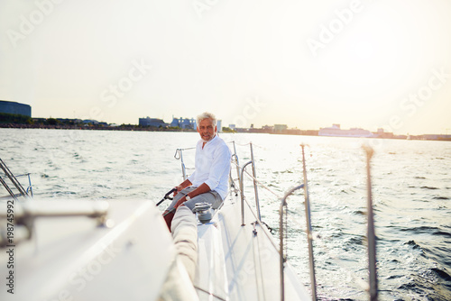 Mature man sailing his boat on the open water © Flamingo Images