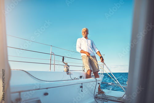 Mature man out for a sail on his boat © Flamingo Images