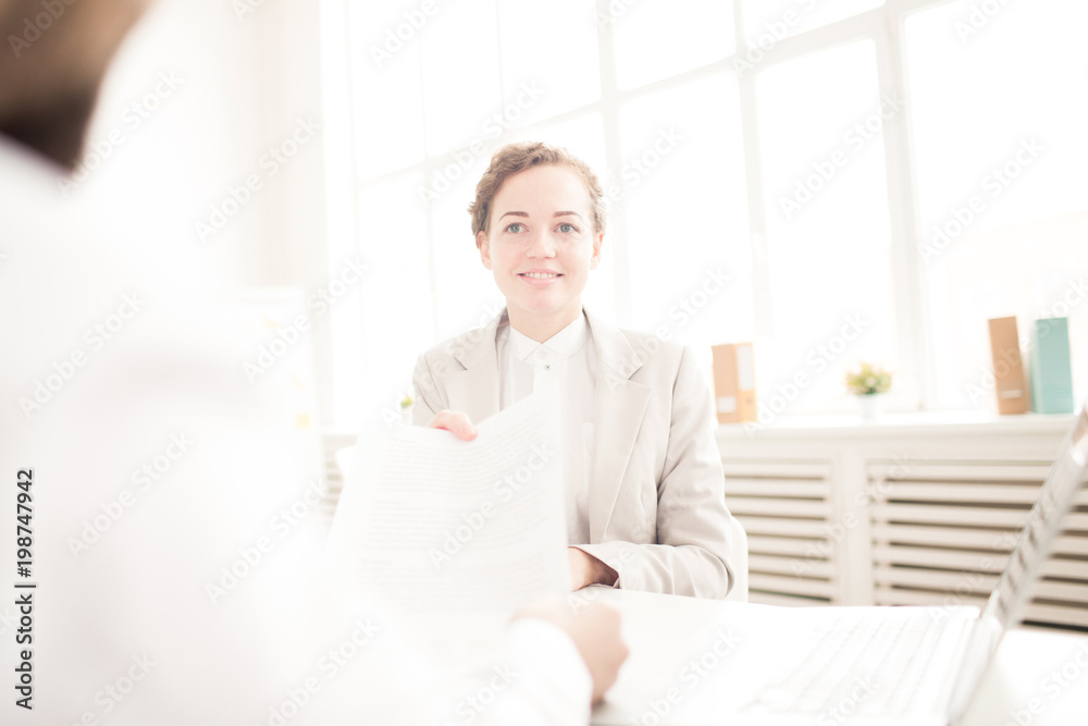 Businesswoman showing a contract to her partner during a meeting Businesswoman showing a contract to her partner during a meeting