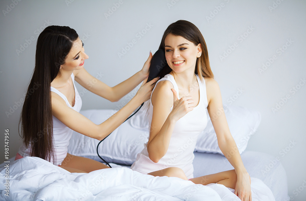 Attractive woman loking at her sister while she combing hair Attractive woman loking at her sister while she combing hair