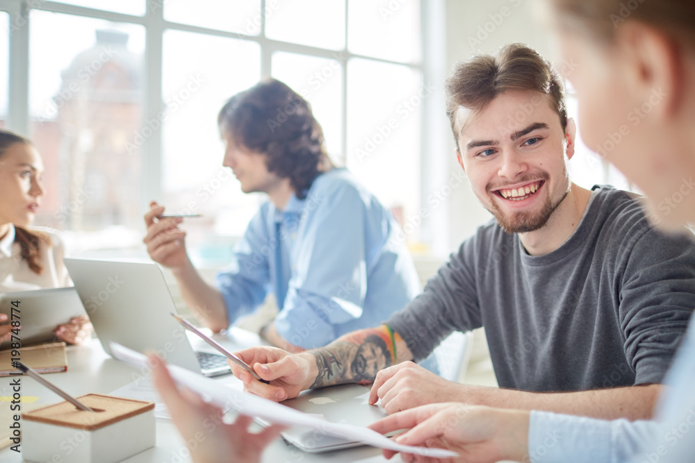 Happy casual businessman working in team with his coworkers at meeting Happy casual businessman working in team with his coworkers at meeting