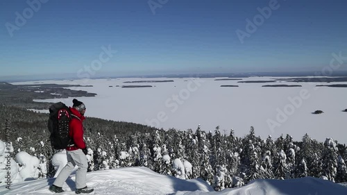 Snowshoe hiker on Koli peak enjoys the winter landscape photo