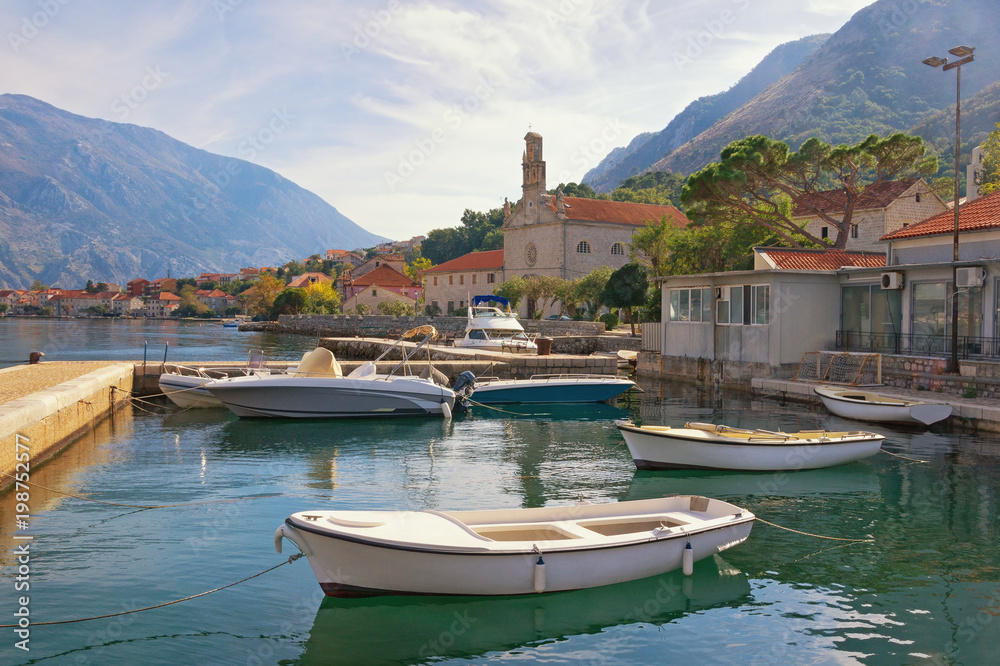 Sunny autumn day. Montenegro, Bay of Kotor.  View of seaside Prcanj town and St. Nicholas Church