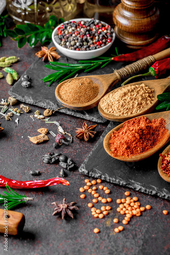 Spices for cooking with kitchen accessories on an old background
