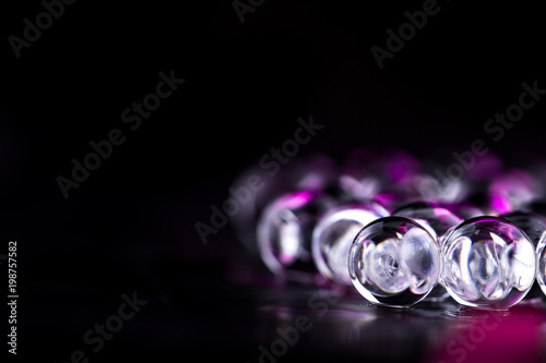Violet and dark water gel balls. Macro photo, can be used both for advertising or cosmetics and for medicine. Abstract background.