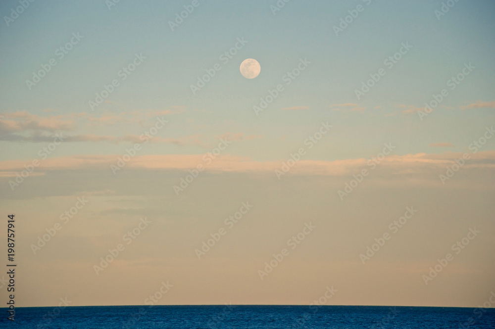 Moon at sunset in the beach