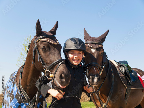 Portrait of happy young girl after winning the showjumping competition with her two horses