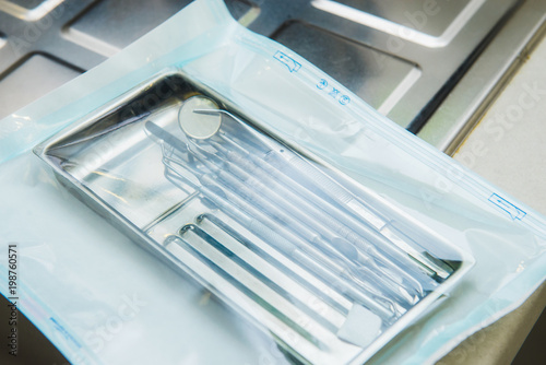 Close up sterilized packaged dentist instruments. Sterility and safety care concept. Selective focus, space for text.