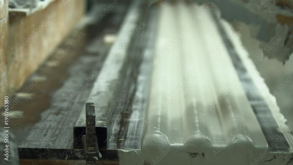 Man working on a machine with gypsum. Builder shaping gypsum product. Italian details of interior. Architecture workshop concept. Man working on a machine with gypsum. Builder shaping gypsum product. Italian details of interior. Architecture workshop concept.