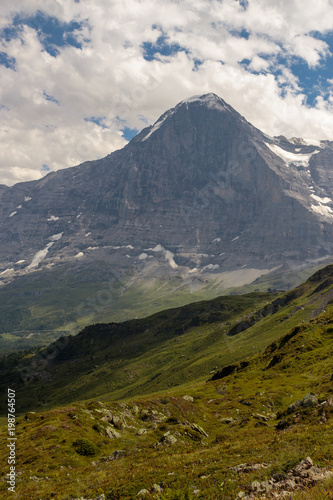 majestic north face of the Eiger under cloudy sky in summer
