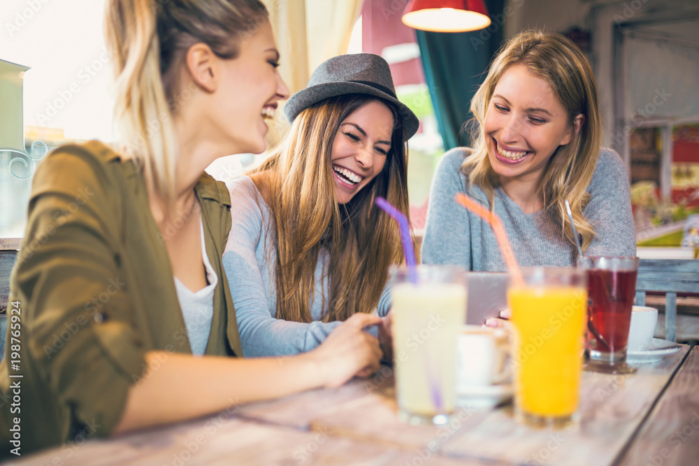 Group of female friends in cafe using digital tablet Group of female friends in cafe using digital tablet
