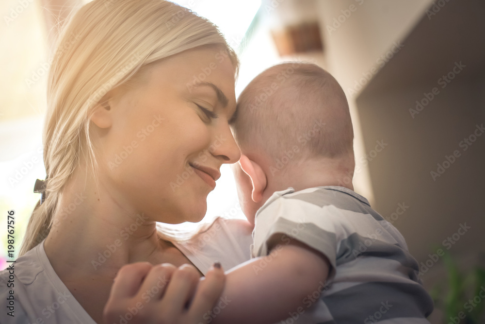 Mother with closed eyes enjoying with her baby boy and holding in arms. Close up. Mother with closed eyes enjoying with her baby boy and holding in arms. Close up.