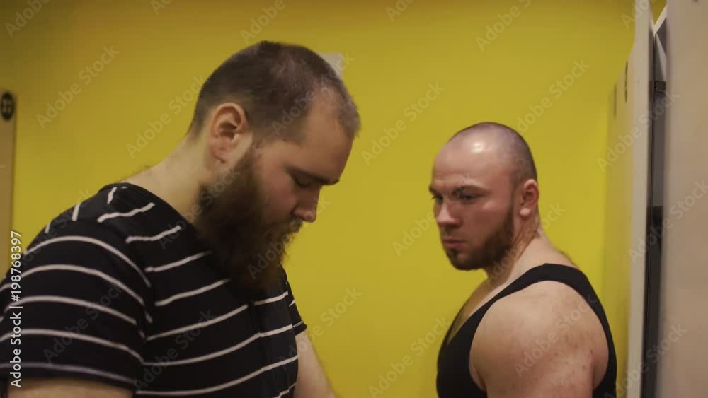 overweight man in the gym in the locker room want to eat donut. overweight man in the gym in the locker room want to eat donut.