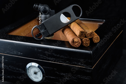Cigars on a humidor against a black background