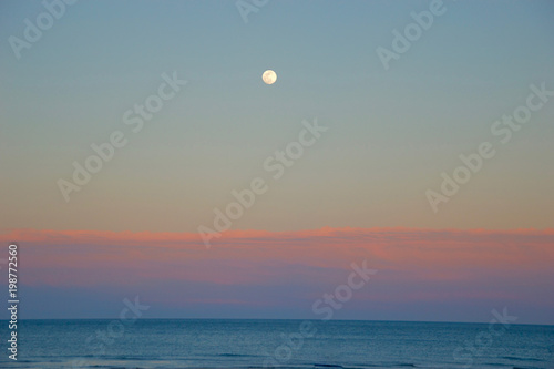 Moon at sunset in the beach