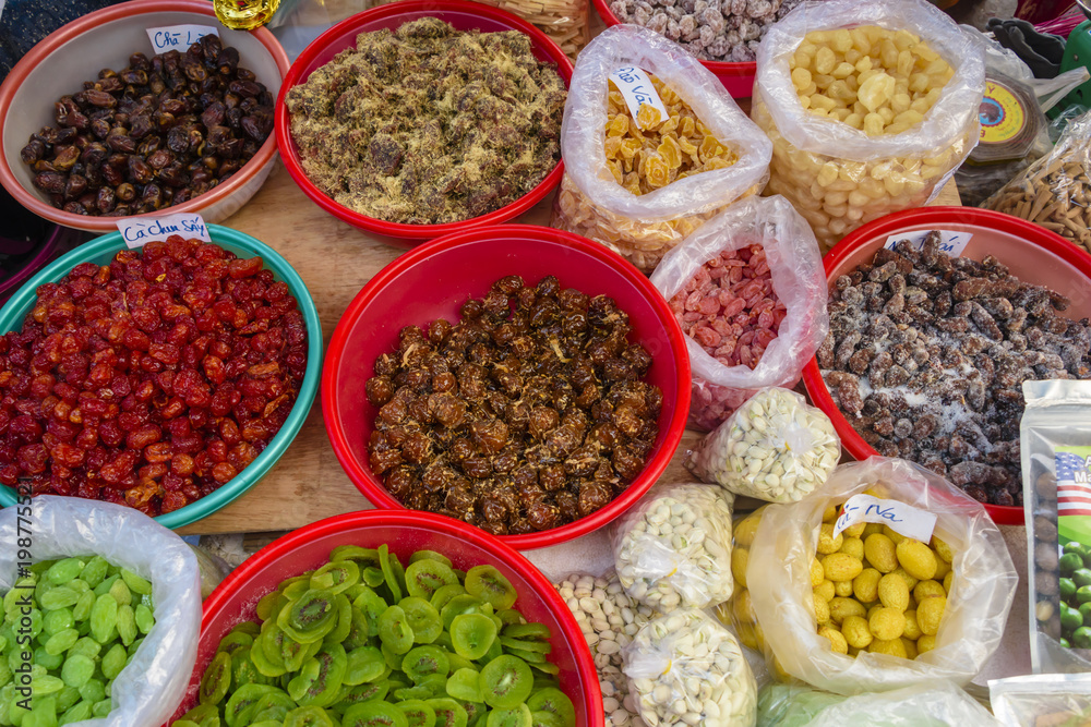 Dried fruit and nuts in bowls for sale at an outdoor market in Hoi An, Vietnam