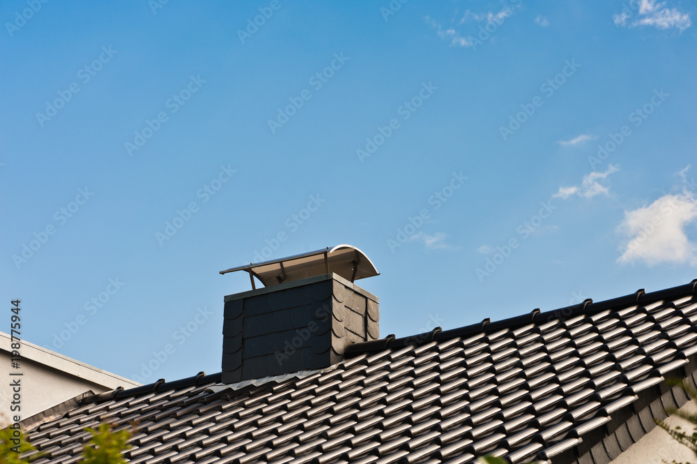 Ein mit Schiefer verkleideter Schornstein mit Kaminhaube in einem neuen  Dach aus Tonziegeln Stock-Foto | Adobe Stock