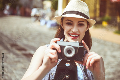 Portrait of happy young female traveler taking photo. Glad tourist concept