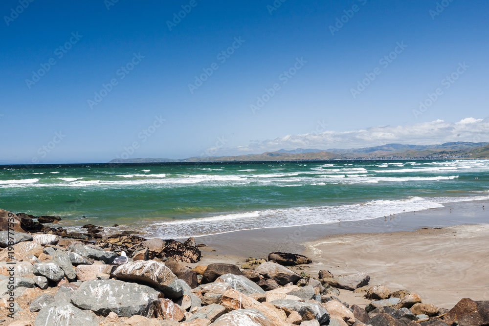A Rocky Beach and a View of the Ocean Waves Breaking, in Morrow Bay, California A Rocky Beach and a View of the Ocean Waves Breaking, in Morrow Bay, California