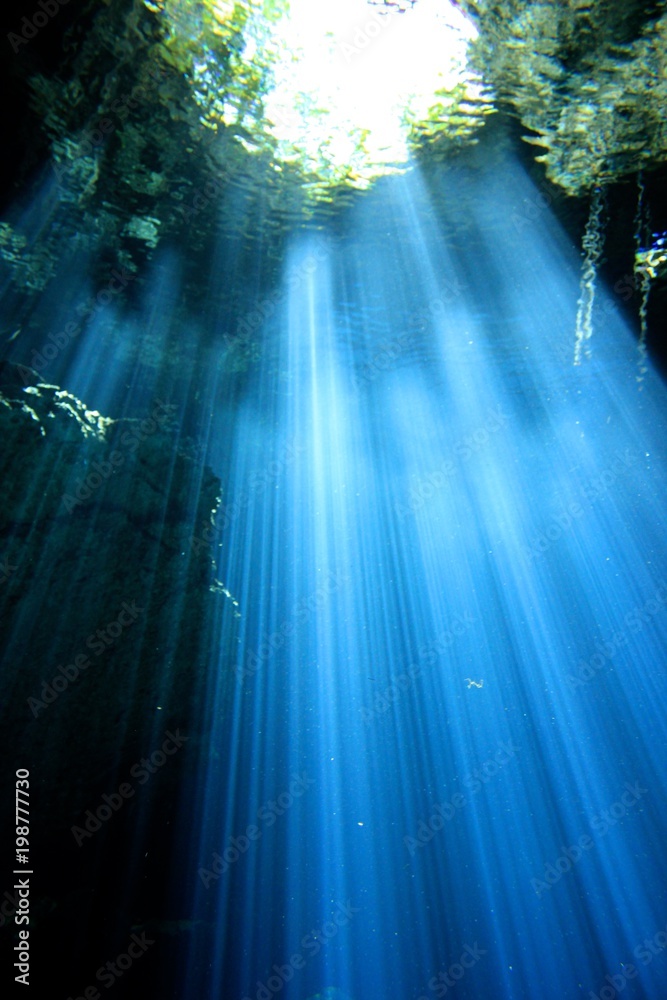 Beautiful beams of light in a Cave and Cavern during a Scuba Diving exploration of a sinkhole or Cenote in the riviera Maya, Mexico