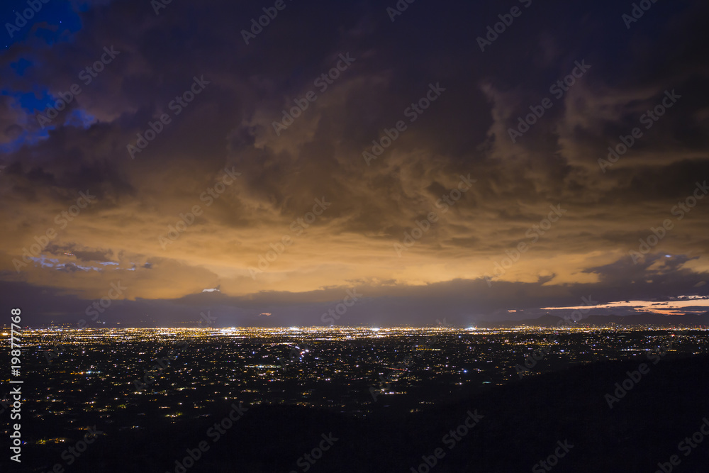 City lights are illuminating dense clouds over Tucson, Arizona.