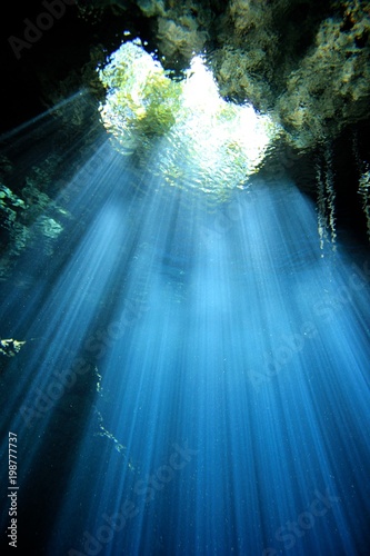 Beautiful beams of light in a Cave and Cavern during a Scuba Diving exploration of a sinkhole or Cenote in the riviera Maya, Mexico