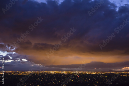 City lights illuminate the bottom of dense clouds over Tucson  Arizona.