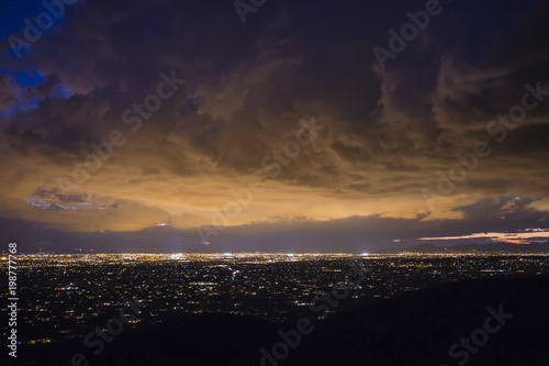 City lights are illuminating dense clouds over Tucson, Arizona.