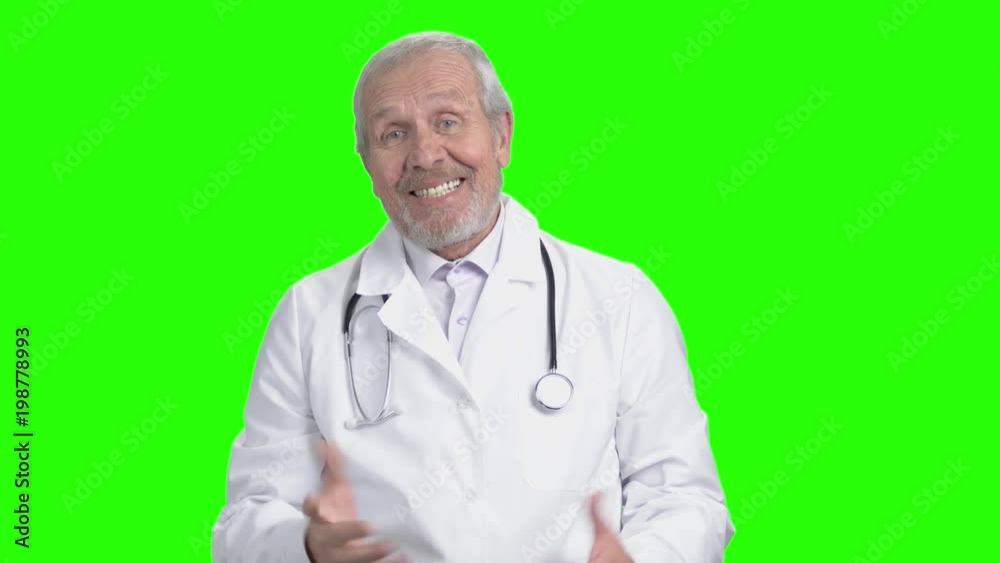 Senior doctor welcoming you and saying hi. Green screen hromakey background for keying. Senior doctor welcoming you and saying hi. Green screen hromakey background for keying.