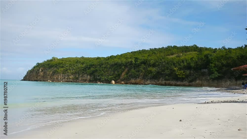 Idyllic tropical Carlisle bay beach with white sand, turquoise ocean water and blue sky at Antigua island Idyllic tropical Carlisle bay beach with white sand, turquoise ocean water and blue sky at Antigua island