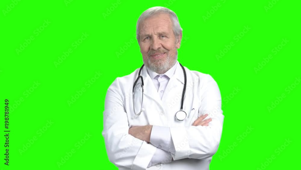 Old smiling doctor with folded arms portrait. Green screen hromakey background for keying. Old smiling doctor with folded arms portrait. Green screen hromakey background for keying.