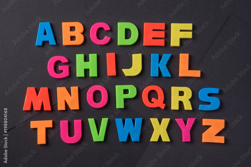 English alphabet of letters of different colors on a black background English alphabet of letters of different colors on a black background