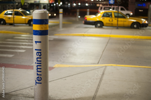 Pole with TERMINAL 1 at the airport of the country side in America. America is a continent where American mainly live.