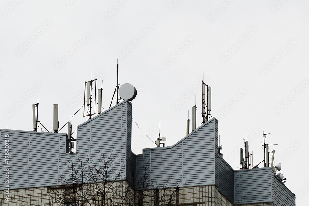 A lot of antenna to provide communication on the roof of the building. A lot of antenna to provide communication on the roof of the building.