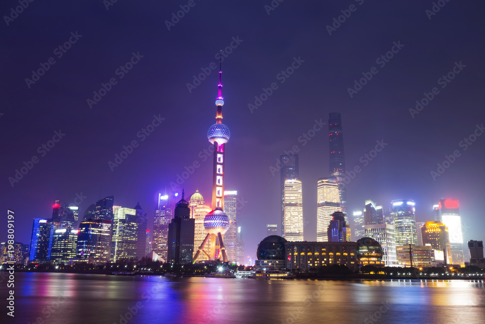 Modern skyscrapers of Shanghai cityscape at night with reflection of beautiful ligth in Huangpu river view from the bund, Shanghai, China