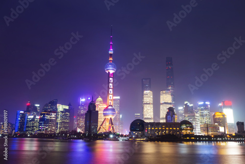 Modern skyscrapers of Shanghai cityscape at night with reflection of beautiful ligth in Huangpu river view from the bund  Shanghai  China