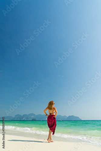 Woman with pink sarong on the tropical beach