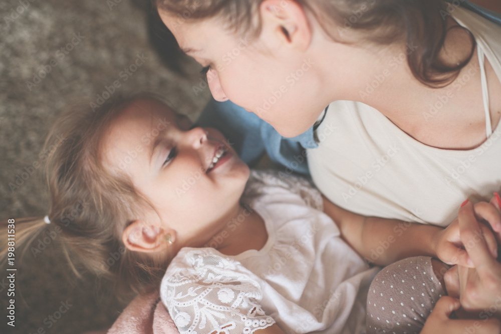 Single mother and daughter playing on floor. Focus on girl. Single mother and daughter playing on floor. Focus on girl.