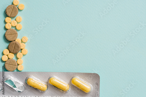 Macro shot detail of yellow oval tablet pills with blister packs on white background with copy space. Pain killer medicine. photo