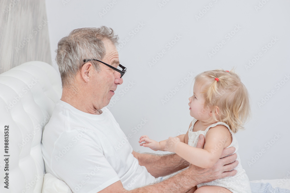 Granddad and baby girl having fun on the bed Granddad and baby girl having fun on the bed