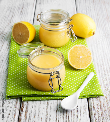 Fotografi Lemon curd in glass jar with fresh lemons