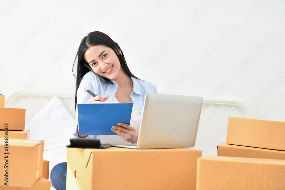Sme business concept. Young people are packing their packages.Delivery business Small and Medium Enterprise (SMEs). Young woman is working in the house.Young Owner Start up for Business Online. Sme business concept. Young people are packing their packages.Delivery business Small and Medium Enterprise (SMEs). Young woman is working in the house.Young Owner Start up for Business Online.