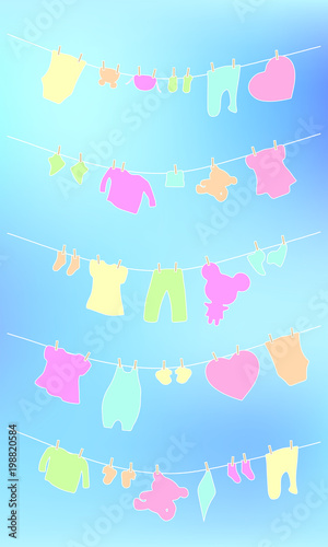  Baby clothes and toys dries on a rope on the sky background