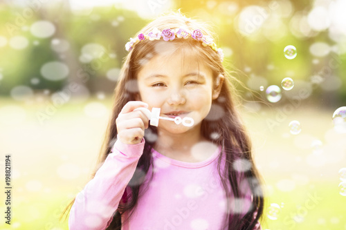 happy little Girl blowing Soap Bubbles.