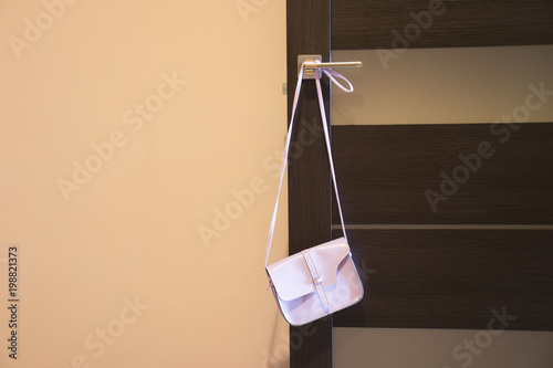 ladies pink handbag hanging on the door photo